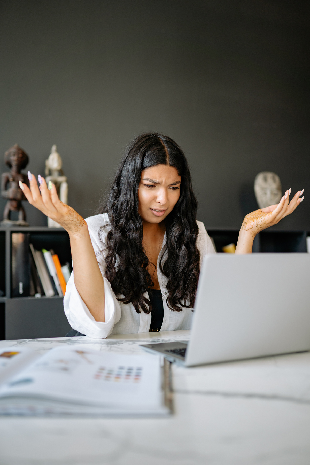 A Confused Woman Looking at her Laptop 